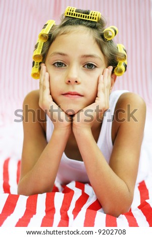 Beautiful girl with hair rollers on a stripy background