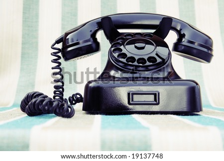 Vintage rotary phone on stripy background
