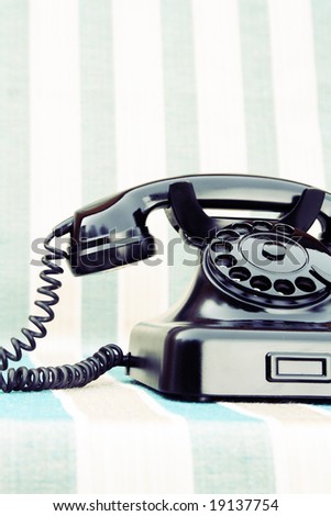 Vintage rotary phone on stripy background
