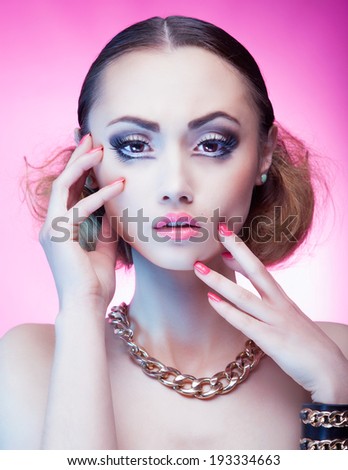 Face close up of beautiful young woman with professional party make up gold chain necklace and bracelet