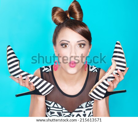 Funny young woman holding high heels shoes