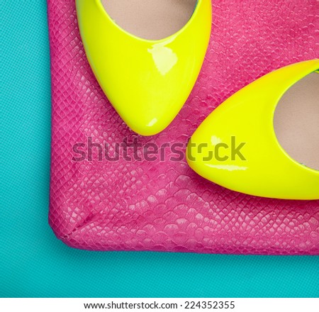 Neon high heels and snakeskin print bag, woman fashion concept