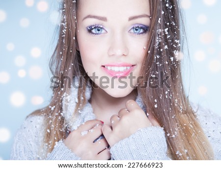 Winter face close up of young attractive woman covered with snow flakes. Christmas concept.