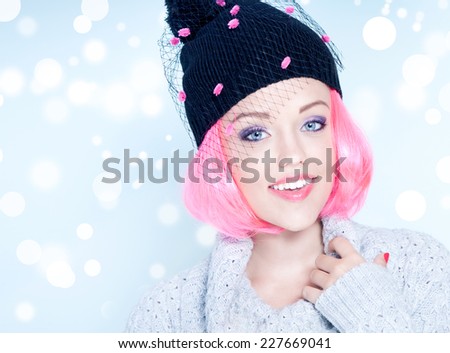 Portrait of young attractive cheerful woman with pink hair wearing fancy winter hat. Christmas concept.