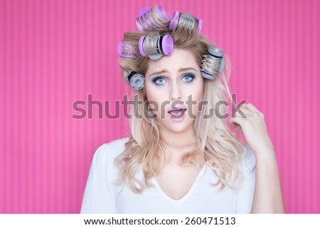 Humorous portrait of young beautiful woman with hot rollers