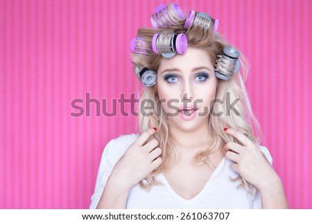 Young attractive blonde woman with hot rollers beauty concept
