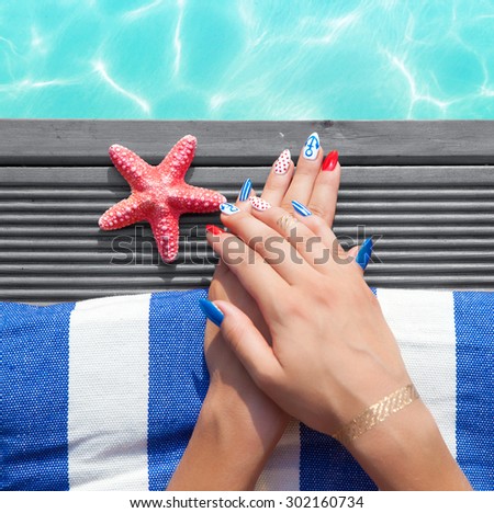 Woman lying down by the pool, marine sailor gel nails close up summer beauty concept