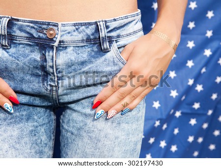 Young woman with marine sailor gel nails manicure holding hand at jeans  pocket