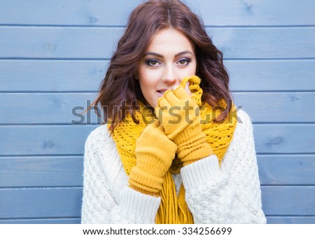 Beautiful natural young smiling brunette woman wearing knitted sweater and gloves. Fall and winter fashion concept.