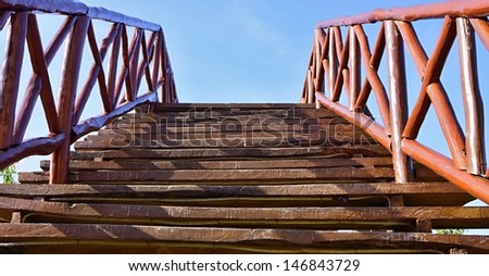 The bridge for pedestrians, is made of wooden boards and bars