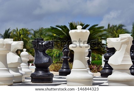 Big black and white figures for game in chess on a beach during rest