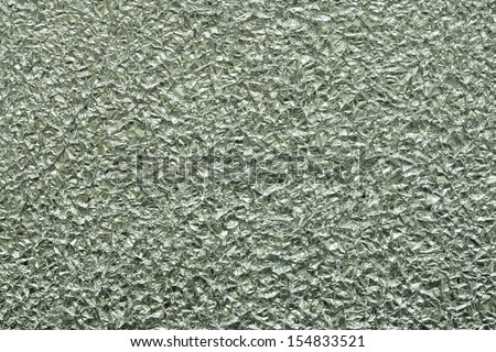 Festive mirror background from a foil of the silvery color, the crumpled texture for decoration of a surface