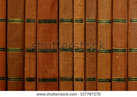 Background from shabby covers of old books, these books are placed vertically in the same row