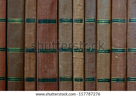 Background from shabby covers of old books, these books are placed vertically in the same row