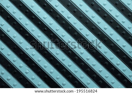fragment of the ancient riveted panel from the painted wooden boards with black blue slanting striped pattern