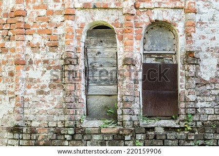 brick wall of the old destroyed building with the broken window niches