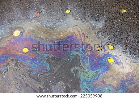 abstract textural pattern of spots of oil or gasoline on wet autumn asphalt