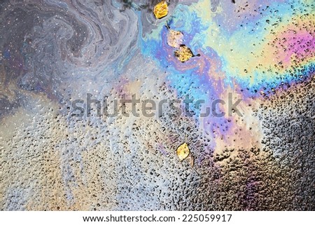 abstract spotty iridescent pattern from brilliant spots of oil or gasoline on wet autumn asphalt