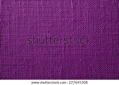 the textured background of synthetic fabric with crisscross fibers of dark lilac color