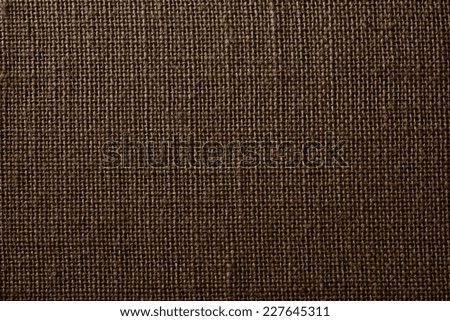 the textured background of synthetic fabric with crisscross fibers of brown color