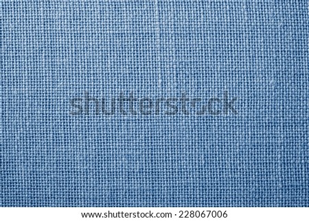 the textured background of synthetic fabric with crisscross fibers of light blue color