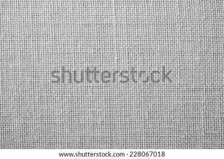 the textured background of synthetic fabric with crisscross fibers of light gray color