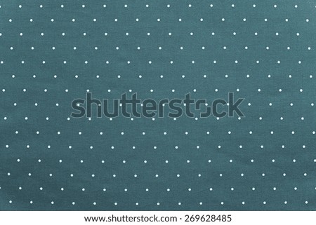 the abstract textured background of indigo color fabric and round light specks are located in ranks on a surface on all area