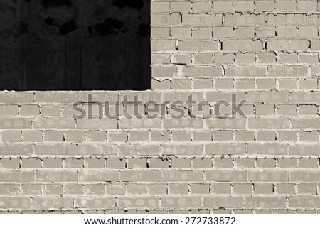 gray brick wall under construction with a window opening for the abstract textured backgrounds