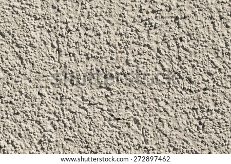 the rough grained surface is plastered in beige color for the textured empty and pure backgrounds