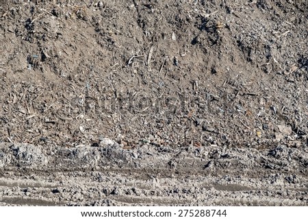 dirty soil and construction garbage in a heap on a big dump for an abstract background of ecology of the nature
