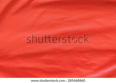 leather of red color with crumpled corrugated grained texture for empty and pure abstract backgrounds