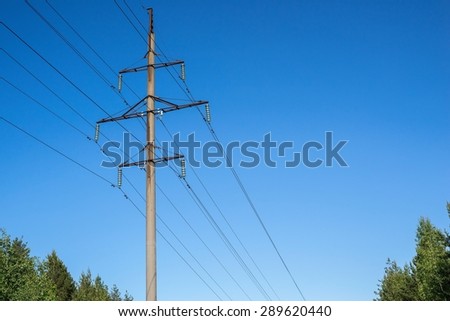 high concrete support column of a high voltage power line against the blue sky and a blank space for the text