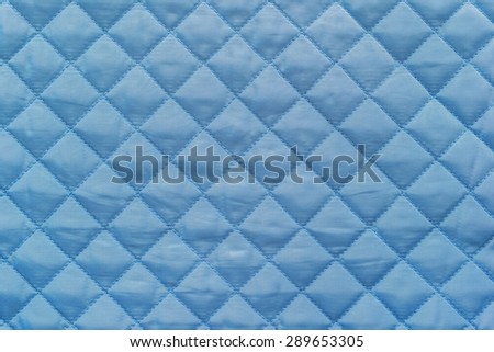 blue quilted synthetic fabric with grained texture for empty and pure abstract backgrounds