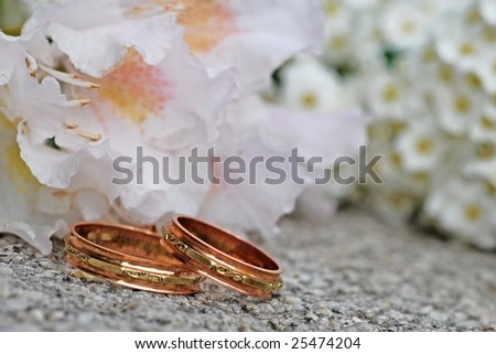 flower and wedding bands on stone