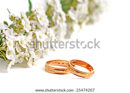 white spring flower and wedding bands on white background