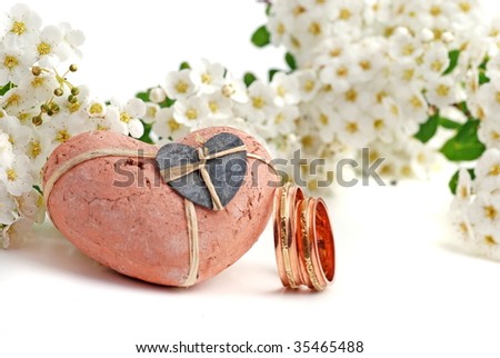 white flower and wedding bands with rosa heart on white