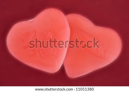 two heart-shaped candies touching each other in a warm and soft atmosphere