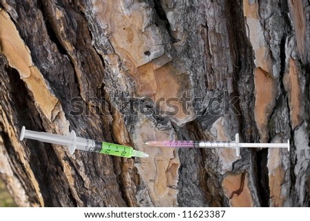 a couple of syringes fitted into a tree, pointing out the concept of drug addiction