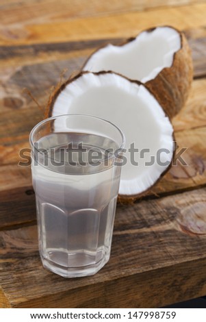Coconut Water. Full Glass Of Fresh Coconut Juice And Coconut On Wooden Table. Shallow Depth Of Field.