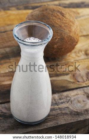 Almond and coconut milk. Healthy blended almond and coconut on wooden table. Studio shot at daylight, shallow depth of field.