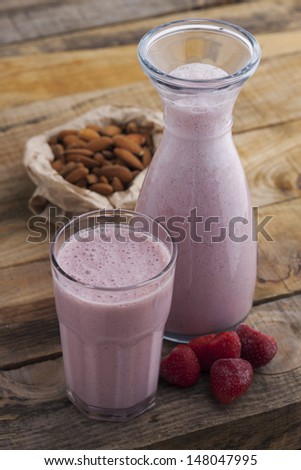 Healthy strawberry and almond milk on wooden table. Studio shot on daylight, shallow dept of field.