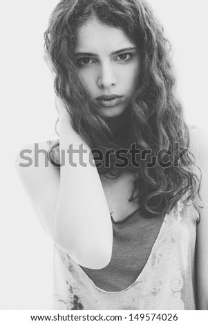 Young woman portrait. Faded black and white image of a beautiful girl. Shallow depth of field. Grain added.