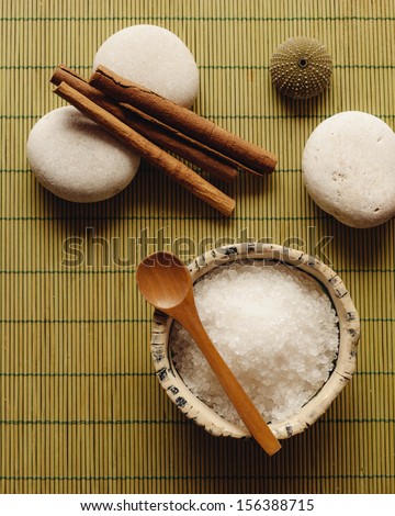 Spa supplies. Sea salt, pebble and cinnamon sticks in a zen spa atmosphere.
