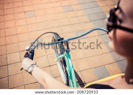 closeup portrait of a stylish girl hipster riding a cruiser bicycle