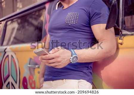 close-up of a man with athletic body holding a smartphone