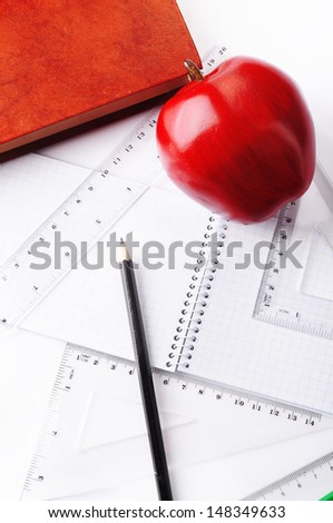school supplies. book, pencil, notebook, ruler and red apple on a white background