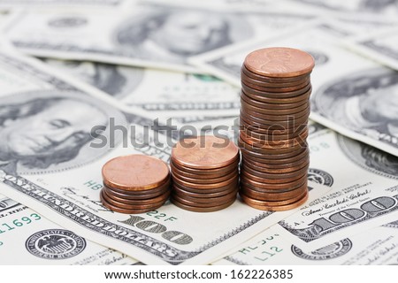 Stack US pennies in an ascending bar graph on background of money american hundred dollar bills