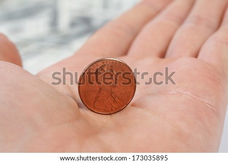 Detailed view standing penny on male hand on background of money american hundred dollar bills