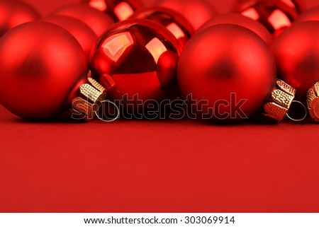 Group of red matt and glossy christmas balls on red background