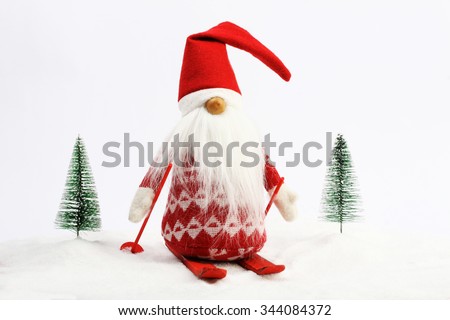 Christmas helper (elf) skiing on snow next two snowy trees\
Red and white colors
